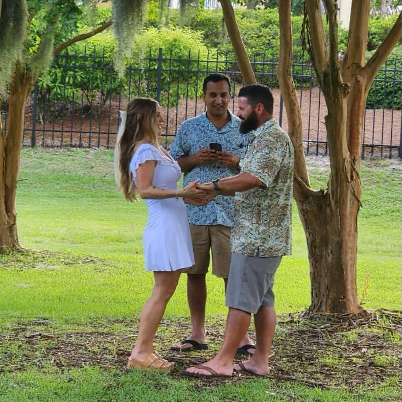 A man wearing the Southern Live Oak Floridian Shirt by Okihasi (right side) getting married to the woman on the left.