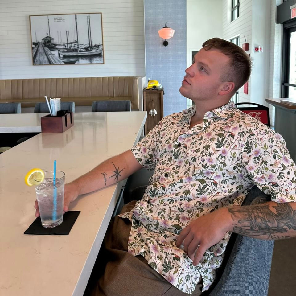 A man wearing the Passionflower Floridian Shirt by Okihasi.