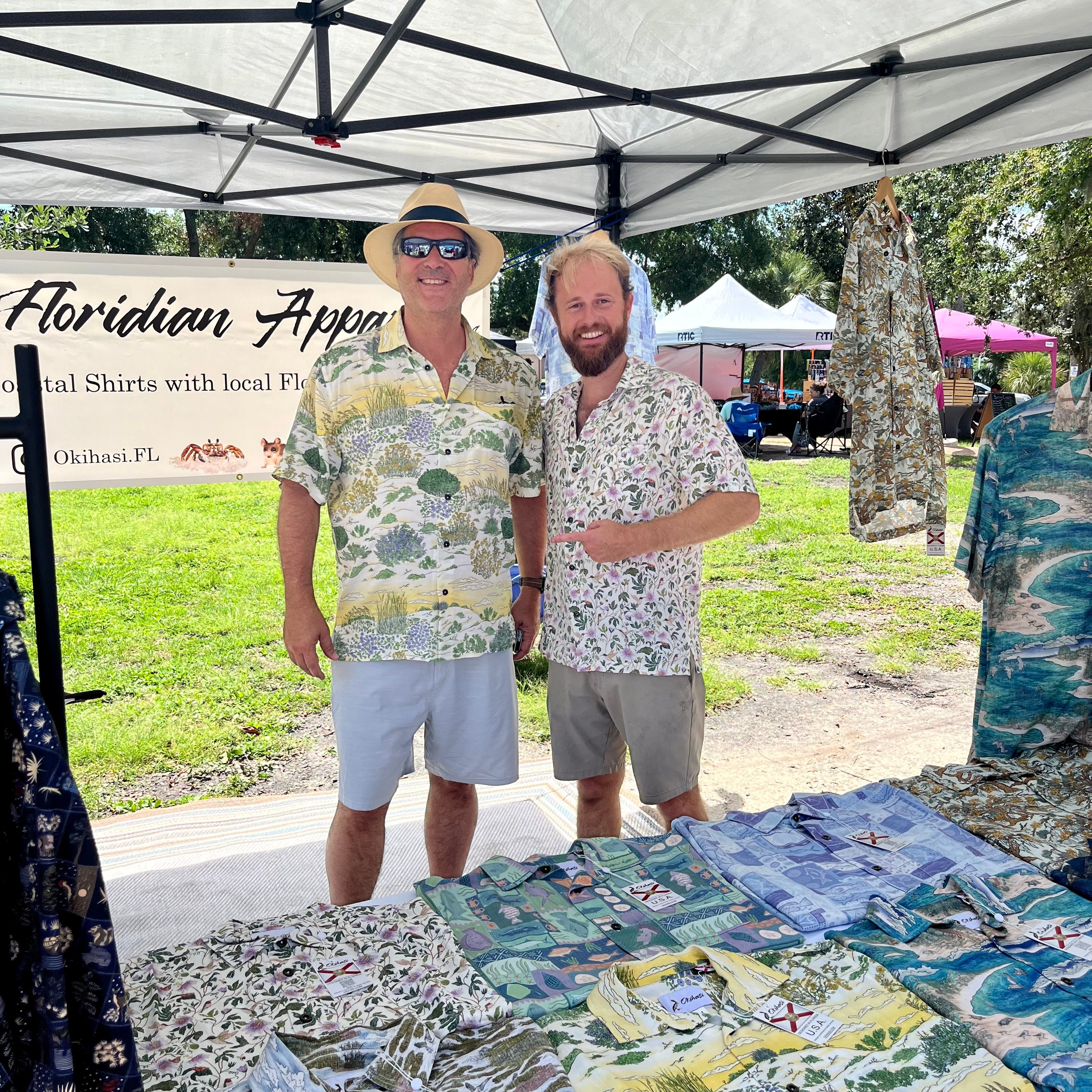 A man (right side) wearing the Passionflower Floridian Shirt by Okihasi standing with another man.